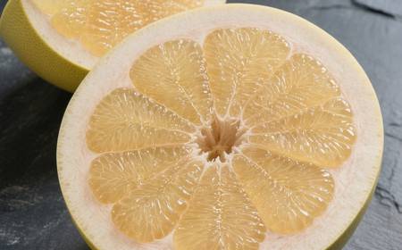 Un pomelo coupé, montrant sa chair juteuse et ses quartiers.